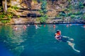 CHICHEN ITZA, MEXICO - NOVEMBER 12, 2017: Unidentified people enjoying the day in the beautiful Ik-Kil Cenote pond with