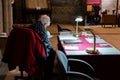 02/05/2020 Chichester, West sussex, UK An elderly lady sitting at a desk reading under lamp light