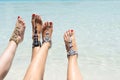 Chick vacation vibe concept. Woman legs with leg jewellery on the tropical white sand beach