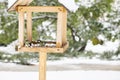 A chickadee in a winter feeder eats bread. The concept of helping birds in winter. Royalty Free Stock Photo