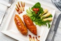 Chicken Adana kebap served with vegetables on white plate
