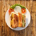 Chicken baguette on plate on bamboo table