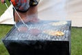 Chicken and beefburgers cooking on a traditional lumpwood charcoal barbecue amid lots of smoke Royalty Free Stock Photo