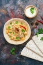 Chicken biryani with yogurt on a rustic background with spices, traditional spicy indian food. Pakistani fried rice.Top view,flat