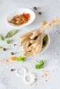 Chicken bones chicken feet, vegetables, spices and herbs for broth on gray background.