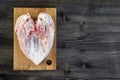 Chicken breast bones up lies on a bamboo cutting Board on a wooden rustic dark background