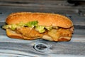 Chicken breast fillet with melted cheddar cheese, lettuce, smoked turkey ham in a bun bread sandwich with ketchup and mayonnaise,