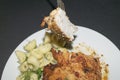 Chicken breast fried with spices, boiled pasta with herbs, a metal fork with a cut piece of breast on a white plate. Royalty Free Stock Photo