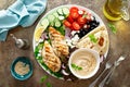 Chicken breast grilled with fresh vegetables, olives, feta cheese, flatbread and hummus, top view Royalty Free Stock Photo