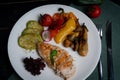 Chicken breast with grilled vegetables on a white plate.