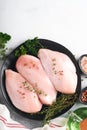 Chicken breast. Raw chicken breast fillets on black ceramic plate on wooden cutting board with herbs and spices on old grey table Royalty Free Stock Photo