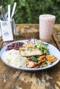 Chicken breast with rice salad, beans, carrots, broccoli, lettuce, red cabbage and a fruit juice Royalty Free Stock Photo