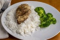 chicken breast and rice served with broccoli