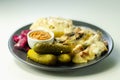 Chicken breast with sliced mushrooms, ham, in cheese sauce with mash potato, pickled red cabbage, and gherkin Royalty Free Stock Photo