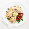 Chicken breasts with parsley, pepper and citrus on white wood background top view