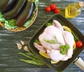 Chicken broiler whole cuisine aubergine gourmet diet cuisine ingredient a frying pan on a white wooden background, tomato, lemon Royalty Free Stock Photo