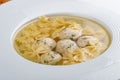 Chicken broth with meatballs and farfallina Royalty Free Stock Photo