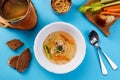 Chicken broth with mushroom noodles and vegetables. Light soup on a blue background.