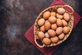 Chicken brown eggs in a basket on a dark painted rustic background. Top view, flat lay, copy space Royalty Free Stock Photo