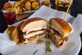 Chicken burger cuted in two halfs with potatoes and beer