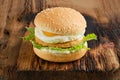 Chicken burger with fried egg and iceberg lettuce on wooden board Royalty Free Stock Photo