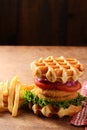 Chicken burger waffle sandwich with lettuce tomato and french fries