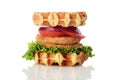 Chicken burger waffle sandwich with lettuce tomato and onion on white