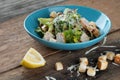 Chicken Cesar salad with croutons, grated cheese and lemon