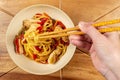 Chicken chow mein and chopsticks on wooden table Royalty Free Stock Photo