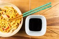 Chicken chow mein and chopsticks on wooden table Royalty Free Stock Photo