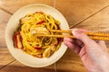 Chicken chow mein and chopsticks on wooden table Royalty Free Stock Photo