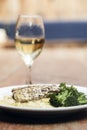 Chicken dish with cream and broccoli and a glass of white wine. Italian fine dinning Royalty Free Stock Photo