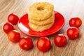 Chicken donut in red plate, tomato cherry around plate on table