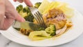 Chicken drumsticks baked with broccoli, and served with green lettuce. Delicious meal on a white plate close-up Royalty Free Stock Photo