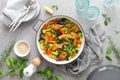 Chicken drumsticks roasted with vegetables in cast iron pan on kitchen table Royalty Free Stock Photo