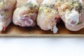 Chicken drumsticks on a wooden board. On white, isolated background.Top view. Flat lay.