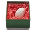 Chicken egg in pink paper nest inside a green box Royalty Free Stock Photo