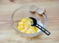 Chicken egg yolks with the sugar in a glass bowl on a wooden background. Royalty Free Stock Photo