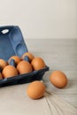 Chicken eggs in a blue package on a gray wooden background. Royalty Free Stock Photo