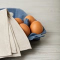 Chicken eggs in a blue package on a gray wooden background. Royalty Free Stock Photo