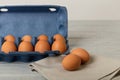 Chicken eggs in a blue package on a gray wooden background. Royalty Free Stock Photo