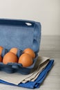 Chicken eggs in a blue package on a gray wooden background. Royalty Free Stock Photo