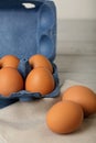 Chicken eggs in a blue package on a gray wooden background. Royalty Free Stock Photo