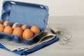 Chicken eggs in a blue package on a gray wooden background. Royalty Free Stock Photo