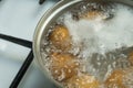 Chicken eggs boil in water. Pan with the product on a gas stove. Royalty Free Stock Photo