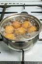 Chicken eggs boil in water. Pan with the product on a gas stove. Royalty Free Stock Photo