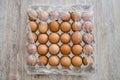 Chicken eggs in a cardboard box, wrapped in plastic wrap on a wooden table. Royalty Free Stock Photo