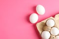 Chicken eggs in carton box on pink background Royalty Free Stock Photo