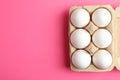 Chicken eggs in carton box on pink background Royalty Free Stock Photo