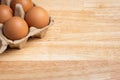 Chicken eggs in carton box on wooden table Royalty Free Stock Photo